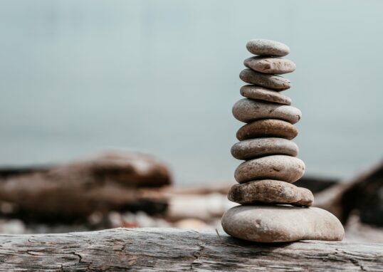 rock stack on log by water
